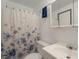 Well-lit bathroom featuring a vanity with sink, toilet, shower with floral curtain and mirrored cabinet at 12931 W 20Th Ave, Golden, CO 80401