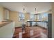 Bright kitchen with white cabinets, stainless steel appliances, and hardwood floors at 3764 Newton St, Denver, CO 80211