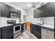 Modern kitchen features black cabinets, stainless steel appliances and light countertops at 2400 N Broadway # 4, Denver, CO 80205