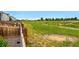 This home's backyard features trees, grassy areas, wooden fence, walking path, and community views at 5779 Piney River Pl, Brighton, CO 80601