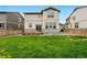 The home's backyard shows a well-maintained lawn and exterior features with wooden fence at 5779 Piney River Pl, Brighton, CO 80601