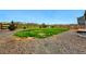 Backyard featuring well-maintained grass, gravel, fenced in yard, and trees at 5779 Piney River Pl, Brighton, CO 80601