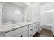 Bright bathroom featuring double sink vanity with marble countertop and white cabinets and trim at 5779 Piney River Pl, Brighton, CO 80601