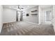 The spacious bedroom features a window, mounted shelves, soft carpet, and neutral paint at 5779 Piney River Pl, Brighton, CO 80601