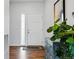Bright entryway with a hardwood floor, plant and chest of drawers, and a front door at 5779 Piney River Pl, Brighton, CO 80601