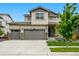 Two-story home showcasing a three-car garage, manicured lawn, and inviting curb appeal at 5779 Piney River Pl, Brighton, CO 80601