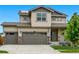 Two-story home showcasing a three-car garage, manicured lawn, and inviting curb appeal at 5779 Piney River Pl, Brighton, CO 80601