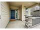 Inviting front porch featuring stone pillar accents and a stylish blue front door at 5779 Piney River Pl, Brighton, CO 80601