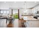 Bright, open-concept kitchen features granite counters, stainless appliances, and bar seating at 5779 Piney River Pl, Brighton, CO 80601