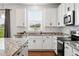 Well-lit kitchen with granite countertops, stainless steel appliances, and ample cabinet space at 5779 Piney River Pl, Brighton, CO 80601