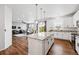 Modern kitchen boasts a center island with granite countertops, white cabinets, and pendant lighting at 5779 Piney River Pl, Brighton, CO 80601