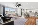 Open-concept living room with hardwood floors, natural light, and modern furnishings at 5779 Piney River Pl, Brighton, CO 80601