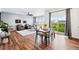 Open-concept living and dining area with hardwood floors and abundant natural light at 5779 Piney River Pl, Brighton, CO 80601