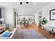 Open-concept living room with hardwood floors, natural light, and modern furnishings at 5779 Piney River Pl, Brighton, CO 80601