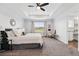 Comfortable main bedroom with plush carpeting, tray ceiling, and decorative lighting at 5779 Piney River Pl, Brighton, CO 80601
