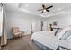 Bright main bedroom showcasing a stylish chair, soft carpet, a ceiling fan, and a door at 5779 Piney River Pl, Brighton, CO 80601