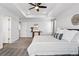 Bright main bedroom features soft carpet, a ceiling fan, and a door leading to other rooms at 5779 Piney River Pl, Brighton, CO 80601