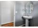 Contemporary powder room with pedestal sink, oval mirror, and modern fixtures at 5779 Piney River Pl, Brighton, CO 80601