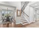 Bright entryway featuring a staircase with black railings, hardwood floors, and an adjacent dining room at 5984 S Paris Pl, Greenwood Village, CO 80111