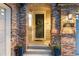 A charming brick entryway featuring a dark front door, wreath, and vibrant potted plants at 5984 S Paris Pl, Greenwood Village, CO 80111