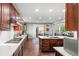 Open-concept kitchen featuring a large island with stone countertops, stainless steel appliances, and wood flooring at 5984 S Paris Pl, Greenwood Village, CO 80111