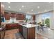 Open kitchen with a large island, stainless steel appliances, wooden cabinets, and an adjacent dining area at 5984 S Paris Pl, Greenwood Village, CO 80111