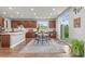 Open kitchen and dining area with wood floors, stainless steel appliances, and natural light at 5984 S Paris Pl, Greenwood Village, CO 80111