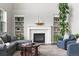 Cozy living room with a fireplace, built-in shelves, comfortable seating, and ample natural light at 5984 S Paris Pl, Greenwood Village, CO 80111