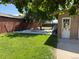 Spacious backyard with green grass, concrete patio with firepit, and access to building at 1000 Denver Ave, Fort Lupton, CO 80621