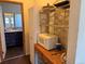Pantry with a microwave, and access to a bathroom with dark cabinets at 1000 Denver Ave, Fort Lupton, CO 80621