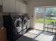 Laundry room with gray cabinets, updated machines, and a backyard view at 1000 Denver Ave, Fort Lupton, CO 80621