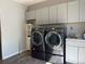 Laundry room featuring gray cabinets and updated machines at 1000 Denver Ave, Fort Lupton, CO 80621