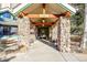 Stone pillars and wood accents mark the entrance to the building at 31819 Rocky Village Dr # 216, Evergreen, CO 80439