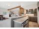 Open bar area showcasing stone counters, wooden cabinets, and an entertainment space near the living area at 33448 Alta Vista Dr, Evergreen, CO 80439