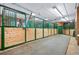 Inside the barn shows horse stalls with wooden framing and green metal bars at 33448 Alta Vista Dr, Evergreen, CO 80439