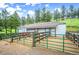 Exterior shot of a barn with a paddock in front and mature trees surrounding it at 33448 Alta Vista Dr, Evergreen, CO 80439