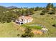 An exterior view of a modern home with a landscaped yard and mountain views at 33448 Alta Vista Dr, Evergreen, CO 80439