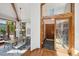 Grand foyer leading to the dining room with wood beams and a modern chandelier at 33448 Alta Vista Dr, Evergreen, CO 80439