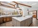 Bright kitchen island with seating, pendant lighting, marble countertops, custom cabinetry and stainless appliances at 33448 Alta Vista Dr, Evergreen, CO 80439