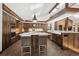 Gourmet kitchen with stainless appliances, stone countertops, island with seating and plentiful custom cabinetry at 33448 Alta Vista Dr, Evergreen, CO 80439