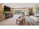 Comfortable living room boasts a stone fireplace, a large sliding door with beautiful outdoor views, and neutral decor at 33448 Alta Vista Dr, Evergreen, CO 80439