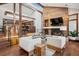 Sunlit living room features a stone fireplace, high ceilings, wood beams, and staircase to open kitchen at 33448 Alta Vista Dr, Evergreen, CO 80439