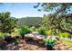 Gorgeous mountain view from a stone bench overlooking lush trees and foliage at 33448 Alta Vista Dr, Evergreen, CO 80439