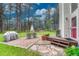 Outdoor space with a brick patio, stone walkway, a dining set, and a view of tall mature trees at 18470 Canterbury Dr, Monument, CO 80132