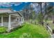 Lush backyard features a cozy porch, mature trees, and a well-kept lawn at 18470 Canterbury Dr, Monument, CO 80132