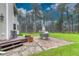 Backyard features a brick patio, a wooden deck, mature trees, and a grassy area for outdoor activities at 18470 Canterbury Dr, Monument, CO 80132