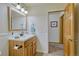 This bathroom features a wooden vanity with white sink, decorative mirror, and beadboard paneling on the lower walls at 18470 Canterbury Dr, Monument, CO 80132