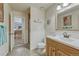 This bathroom features tile floors, a vanity with wood cabinets, wainscotting, and a view into an adjacent room at 18470 Canterbury Dr, Monument, CO 80132