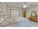 Cozy bedroom features a bed with patterned quilt, an antique vanity, and closet doors with wood trim at 18470 Canterbury Dr, Monument, CO 80132