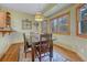 Cozy dining room with wood floors, complemented by a colorful rug and natural light from the surrounding windows at 18470 Canterbury Dr, Monument, CO 80132